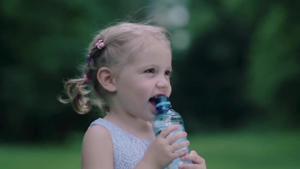 Su iç. Küçük kız şişeden su içiyor. — Stok video