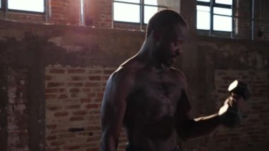 Spor adamı spor salonunda kol egzersizi yapıyor.