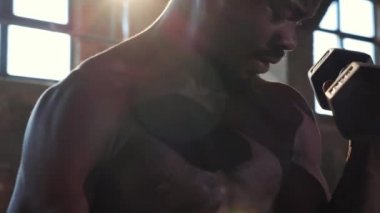 Spor adamı spor salonunda kol egzersizi yapıyor.