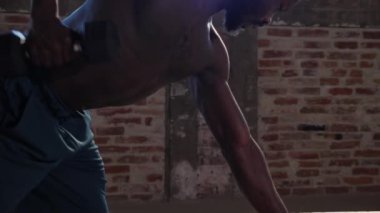 Spor adamı spor salonunda ağırlık çalışıyor.