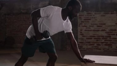 Spor adamı spor salonunda ağırlık çalışırken sırt egzersizi yapıyor.