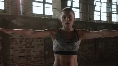 Egzersiz yap. Formda bir kadın spor salonunda spor yapmadan önce ısınıyor.