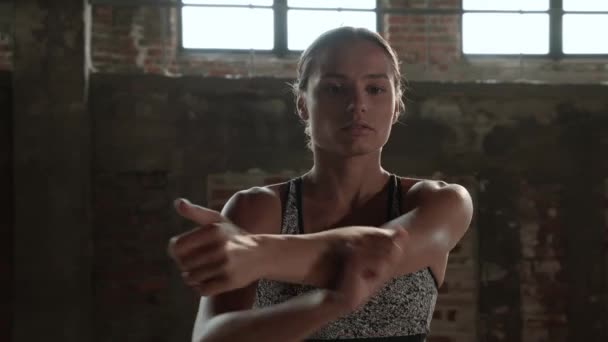 Αθλητική γυναίκα τεντώνει τα χέρια πριν από την προπόνηση γυμναστήριο — Αρχείο Βίντεο