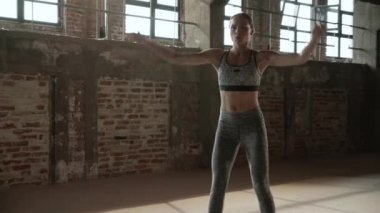 Formda bir kadın spor salonunda zıplama egzersizi yapıyor.