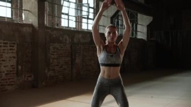 Formda bir kadın spor salonunda zıplama egzersizi yapıyor.