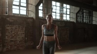 Formda bir kadın spor salonunda zıplama egzersizi yapıyor.