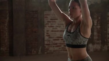 Formda bir kadın spor salonunda zıplama egzersizi yapıyor.