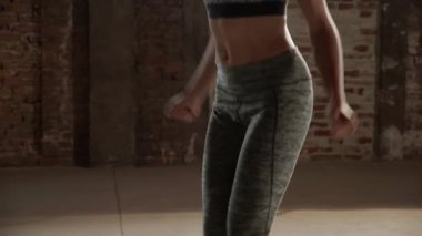 Formda bir kadın spor salonunda zıplama egzersizi yapıyor.