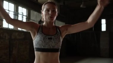 Formda bir kadın spor salonunda zıplama egzersizi yapıyor.