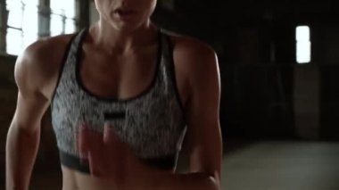 Antrenman yapıyorum. Kadın spor salonunda diz çökmüş koşuyor.