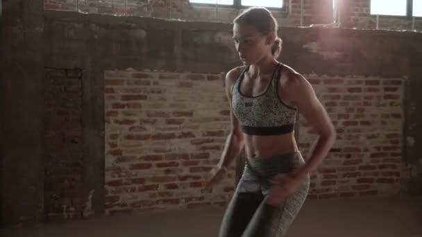Γυμνάζομαι. Γυναίκα κάνει ψηλά γόνατα τρέχει σε θέση άσκησης στο γυμναστήριο — Αρχείο Βίντεο