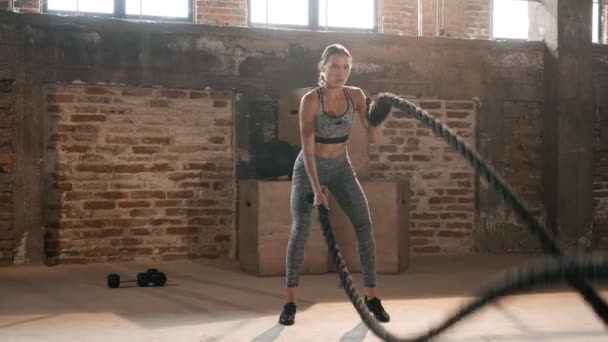 Allenamento fitness. Donna sportiva che fa esercizio di corda da battaglia in palestra — Video Stock