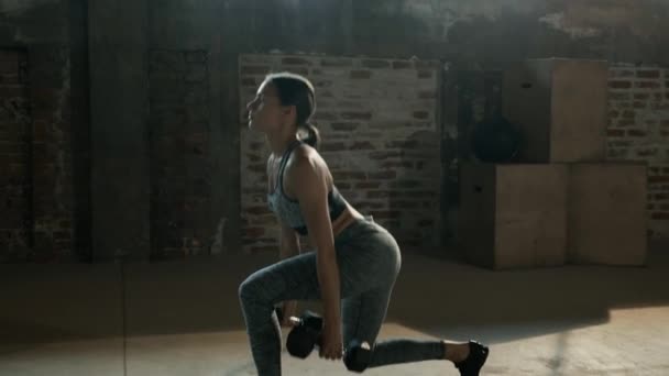 Тренировка. Женщина делает упражнения для ног с гантелями в спортзале — стоковое видео