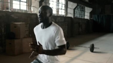 Egzersiz yap. Formda bir adam spor salonunda kardiyo çalışması yapıyor.