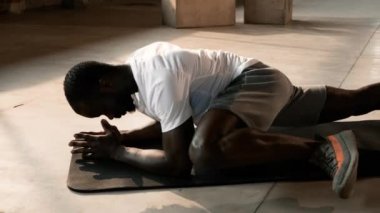 Antrenman yapıyorum. Siyah sporcu spor salonunda tayt için tahta egzersizi yapıyor.