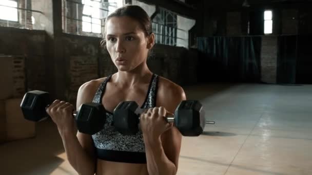 Adatta donna che fa esercizio del braccio con peso sull'allenamento in palestra — Video Stock
