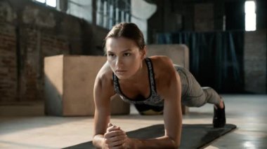 Spor salonundaki spor salonunda beden eğitimi yapan bir kadın.
