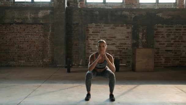 Фитнес-тренировка. Спортивная женщина делает упражнения на ногах в спортзале — стоковое видео