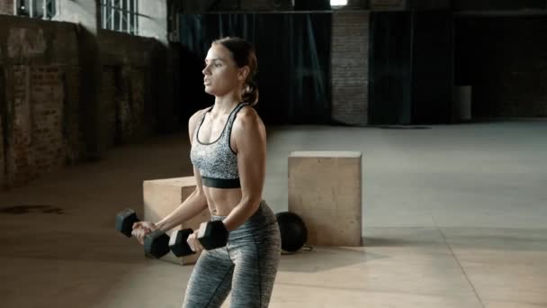 フィット女性はジムでのワークアウトの重量で腕の運動を行う — ストック動画