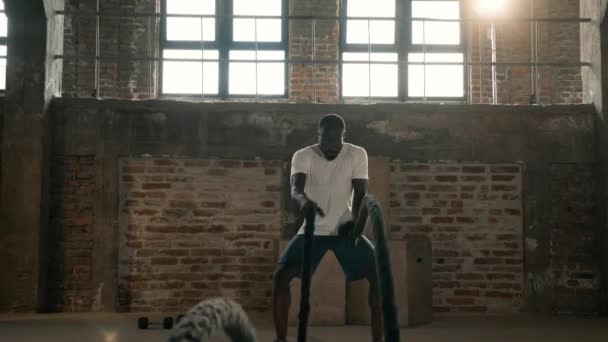 Treino de fitness. Homem do esporte fazendo exercício de corda de batalha no ginásio — Vídeo de Stock