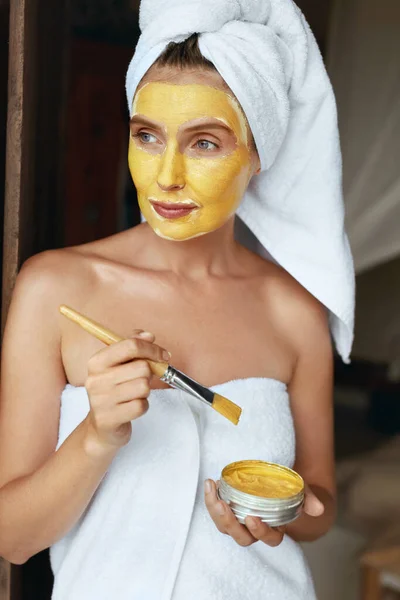 Vrouw in badhanddoek die Clay Mask op het gezicht aanbrengt. Portret van jonge vrouw met schoonheid product op de gezichtshuid. Model met dagelijkse routine voor gezonde Derma op Tropical Resort. — Stockfoto