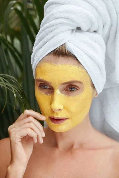 Vrouw met kleimasker op gezicht. Vrouw in bad handdoek op SPA procedure in Resort Portret. Naakte schouders model met huidverzorging product op gezicht derma op zoek weg. — Stockfoto
