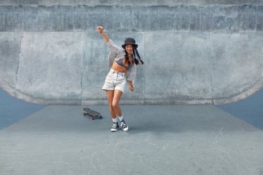 Kaykay yapmak. Kaykay pistinde beton duvara karşı kaykaylı Asyalı bir kız. Aktif gençlerin hobisi olarak şehir sporu. Kaykaycı Alt Kültürü ve Yaşam Tarzı olarak Yaz Etkinliği.