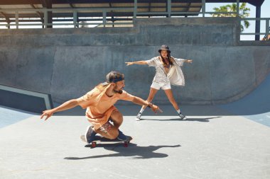 Kaykay yapmak. Kaykay yapan, kaykaylı arkadaşlar kaykay pistinde beton rampadan kayıyorlar. Kaykaycı alt kültürü ve yaşam tarzı olarak yaz etkinliği. Etkin Kentsel Erkekler ve Kızlar İçin Aşırı Spor.