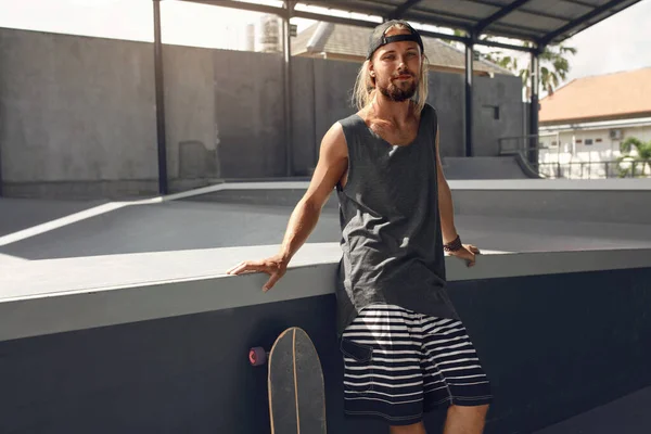 Retrato do Homem Patinador. Hipster In Casual Outfit Sentado na rampa de concreto no Skatepark. Subcultura urbana e skate como estilo de vida de caras ativos na cidade. — Fotografia de Stock