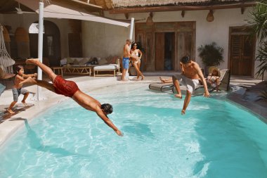 Yaz etkinliği. Tropikal Tatil Merkezinde Aile Tatilinde Havuz Eğlencesi. Oğlu olan ebeveynler, kızları ve erkek arkadaşları hafta sonları eğleniyorlar. Bir grup mutlu insan birlikte eğleniyor..