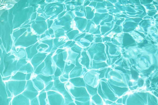 Vatten i pool textur. Turkos ren Aqua yta med krusningar och Glares mönster. Färsk vätska med solljus reflektion på sommaren. — Stockfoto