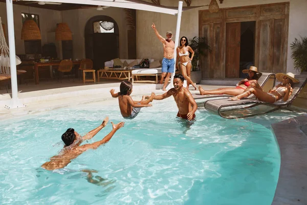 Nyári szórakozás a medencében. Egy csoport ember, akik jól érzik magukat a családi nyaraláson a trópusi üdülőhelyen. Szabadidő a hétvégén, mint életmód. — Stock Fotó