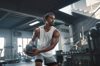 Kettlebell Spor Salonundaki Adam. Güçlü, sağlıklı, kaslı, ağır spor aletleri kullanan seksi Asyalı sporcu. Vücut geliştirme için yaşam stili olarak spor salonunda eğitim.