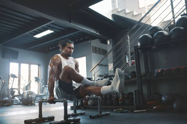 Тренажерный зал Sportsman Using Parallettes for L-Sit Abs Workout. Азиатский человек упражнения с фитнес-оборудования в помещении. Портрет сексуального парня с сильным, здоровым, мускулистым телом. — стоковое фото
