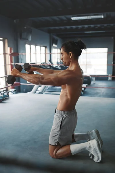 Spor. Boks ringinde dambıllarla çalışan adam. Jimnastik salonunda spor aletleri ile yakışıklı Asyalı sporcu eğitimi. Tişörtsüz Seksi Adam Güçlü, sağlıklı ve kaslı Vücut İçin Egzersiz Yapıyor. — Stok fotoğraf