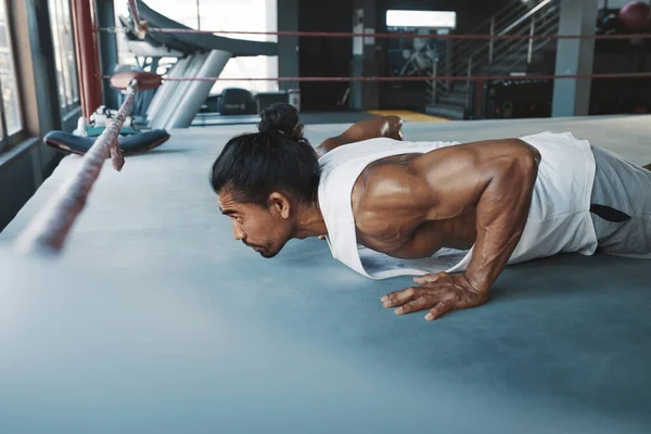 Antrenman yapıyorum. Adam boks ringinde şınav çekiyor. Asyalı sporcu güçlü, sağlıklı ve kaslı vücut egzersizi yapıyor. Spor salonunda seksi adam eğitimi.. — Stok fotoğraf