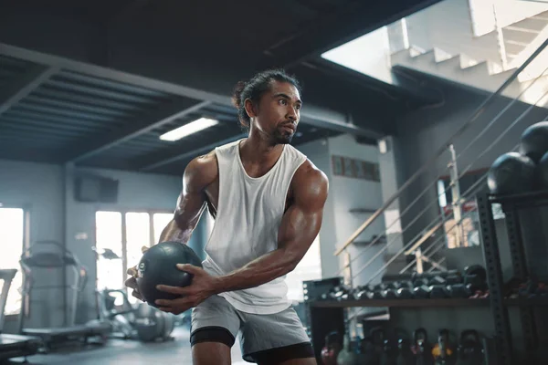 Hombre en entrenamiento de Kettlebell. Sexy deportista asiático con fuerte, saludable, cuerpo muscular usando equipo de fitness pesado. Entrenamiento en el gimnasio para el levantamiento de pesas como estilo de vida. — Foto de Stock