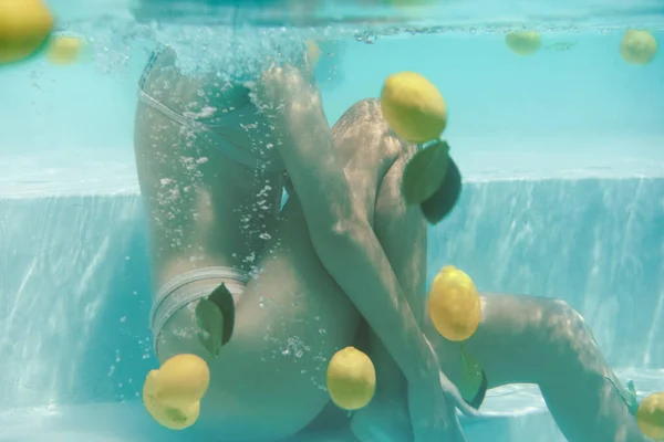 Womans Body Underwater. Modelo sexy en bikini flotando en la piscina con cítricos frescos en el SPA. — Foto de Stock