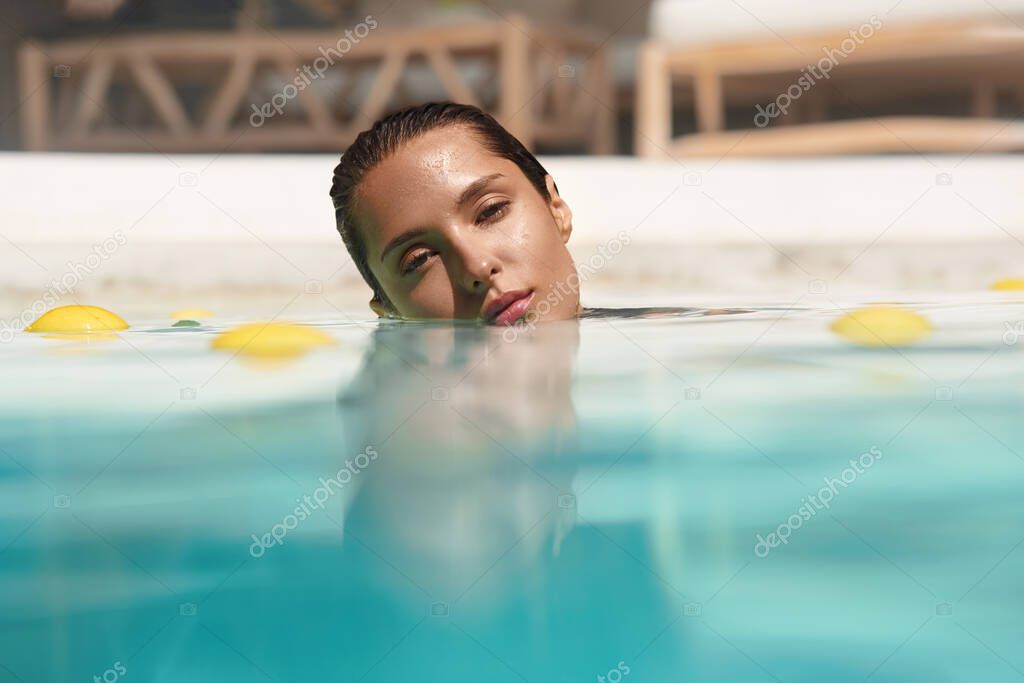 Beautiful Womans Portrait In Pool With Citrus. SPA Treatment For Natural Beauty.