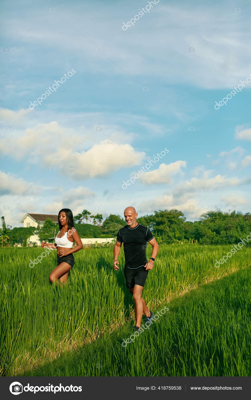Pareja madura corriendo en el campo de arroz por la mañana. Caucásico  hombre y asiático mujer en trotar entrenamiento entre verde hierba contra  tropical paisaje.: fotografía de stock © puhhha #418759538