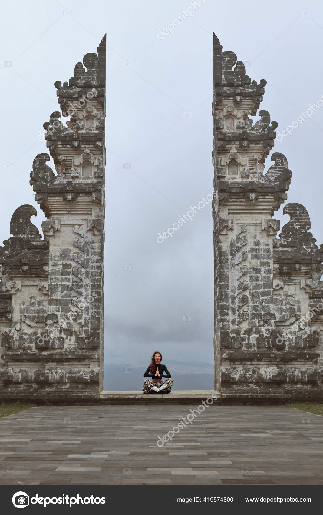 Vertical shot a Caucasian woman doing yoga poses inside an Indian temple  Stock Photo by wirestock