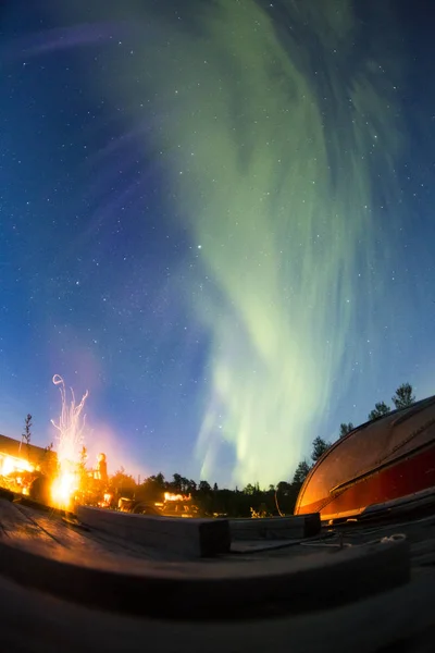 Camp at starry night with polar lights and bonfire.