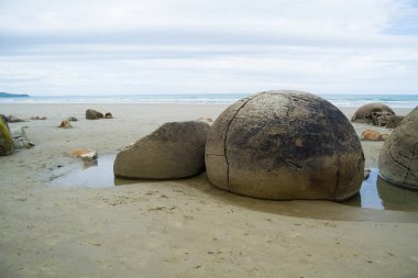 Kum üzerinde yuvarlak kayalar ile Seashore