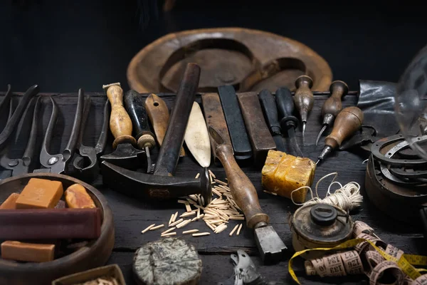 Display of vintage shoemaker manual tools on wooden table