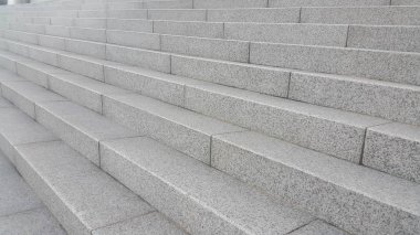 Yakın plan gri beton merdivenler ve ayak izlerinde koyu beton çizgiler.