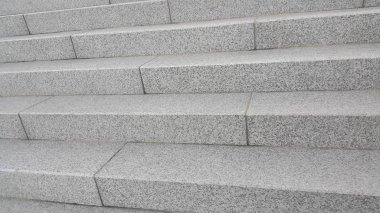 Yakın plan gri beton merdivenler ve ayak izlerinde koyu beton çizgiler.