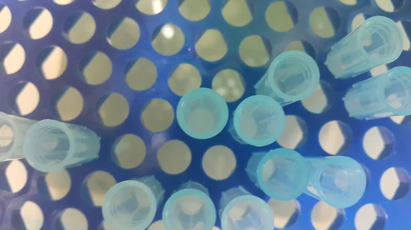 Close up view of blue micro litre tips in microtip box with empty holes. Reseach lab. tool for accurate measurement.