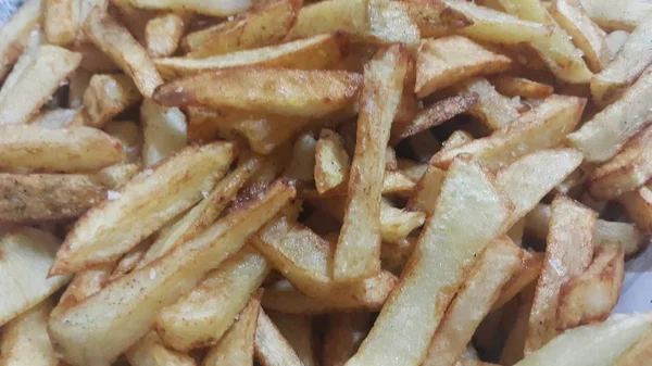 Vista de perto de batatas fritas ou palitos de batata assados — Fotografia de Stock