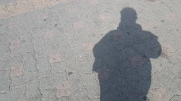 Silhouette : L'ombre d'un homme sur le sol en béton de couleur rouge — Photo