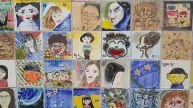 Anılar için duvardaki insanların resimleri ve heykel yüzleri.